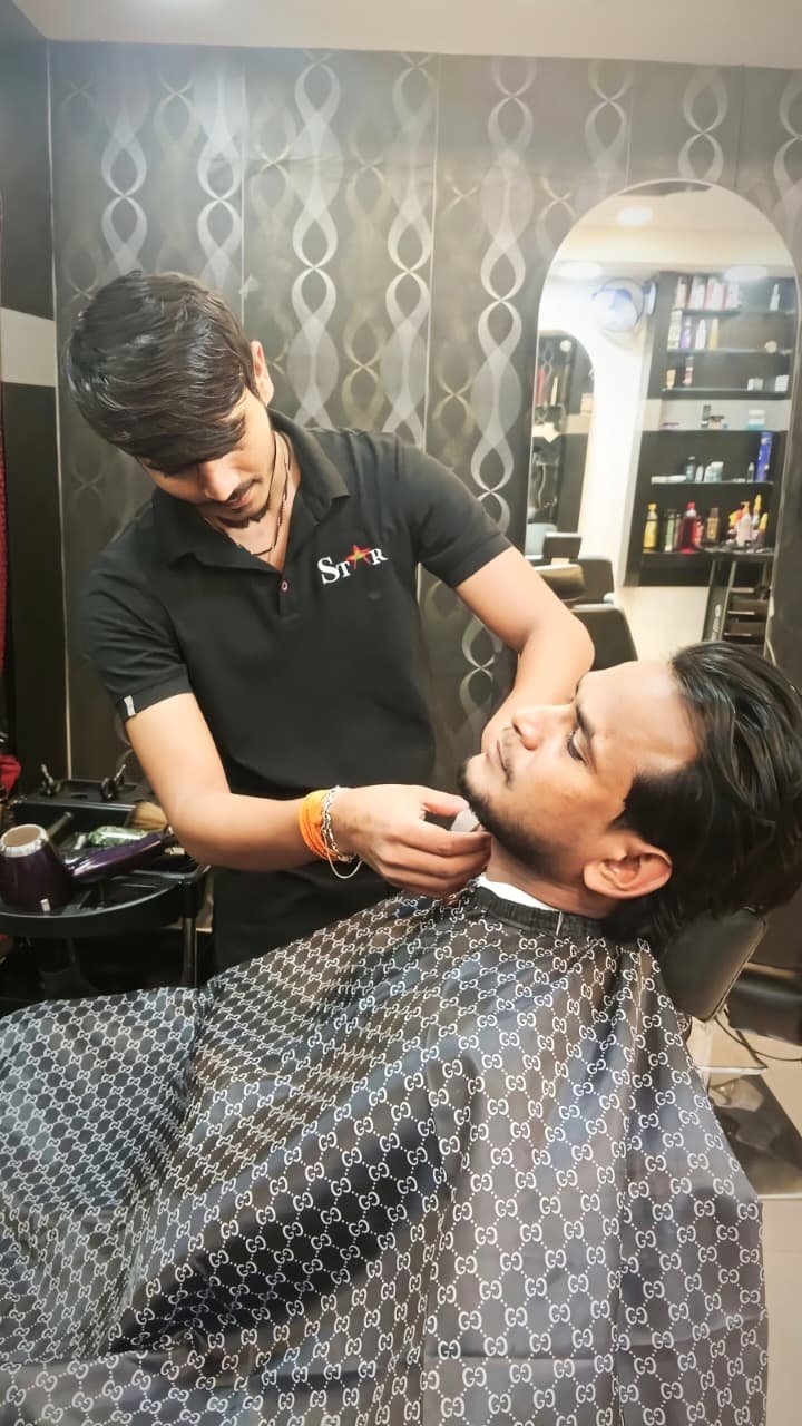Barber giving a beard trim at STAR Men's Professional Salon
